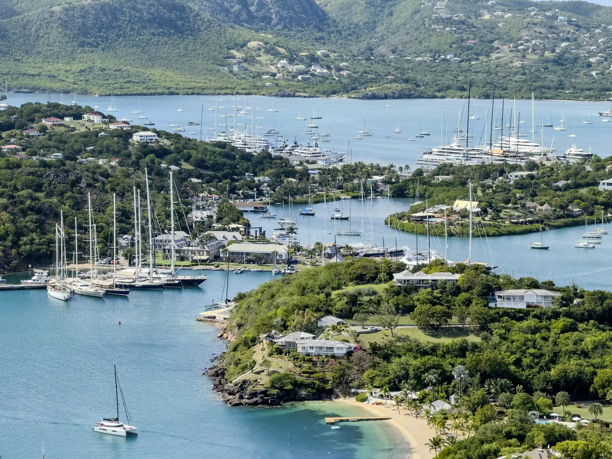 Yachts at anchor in English Harbour, Antigua, below green hills – Antigua and Barbuda citizenship by investment