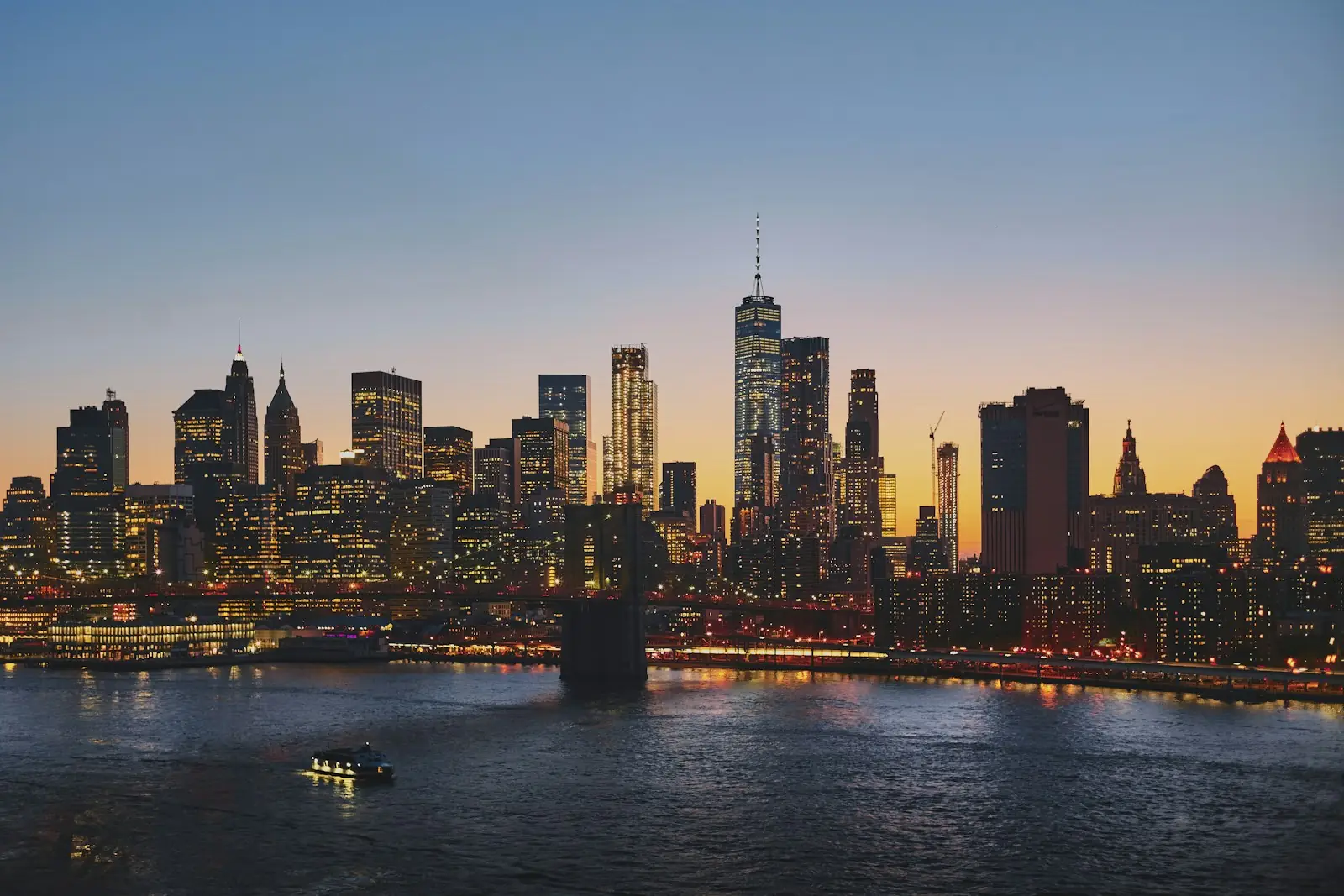 Lower Manhattan skyline and Brooklyn Bridge at dusk, New York – United States Residency by Investment