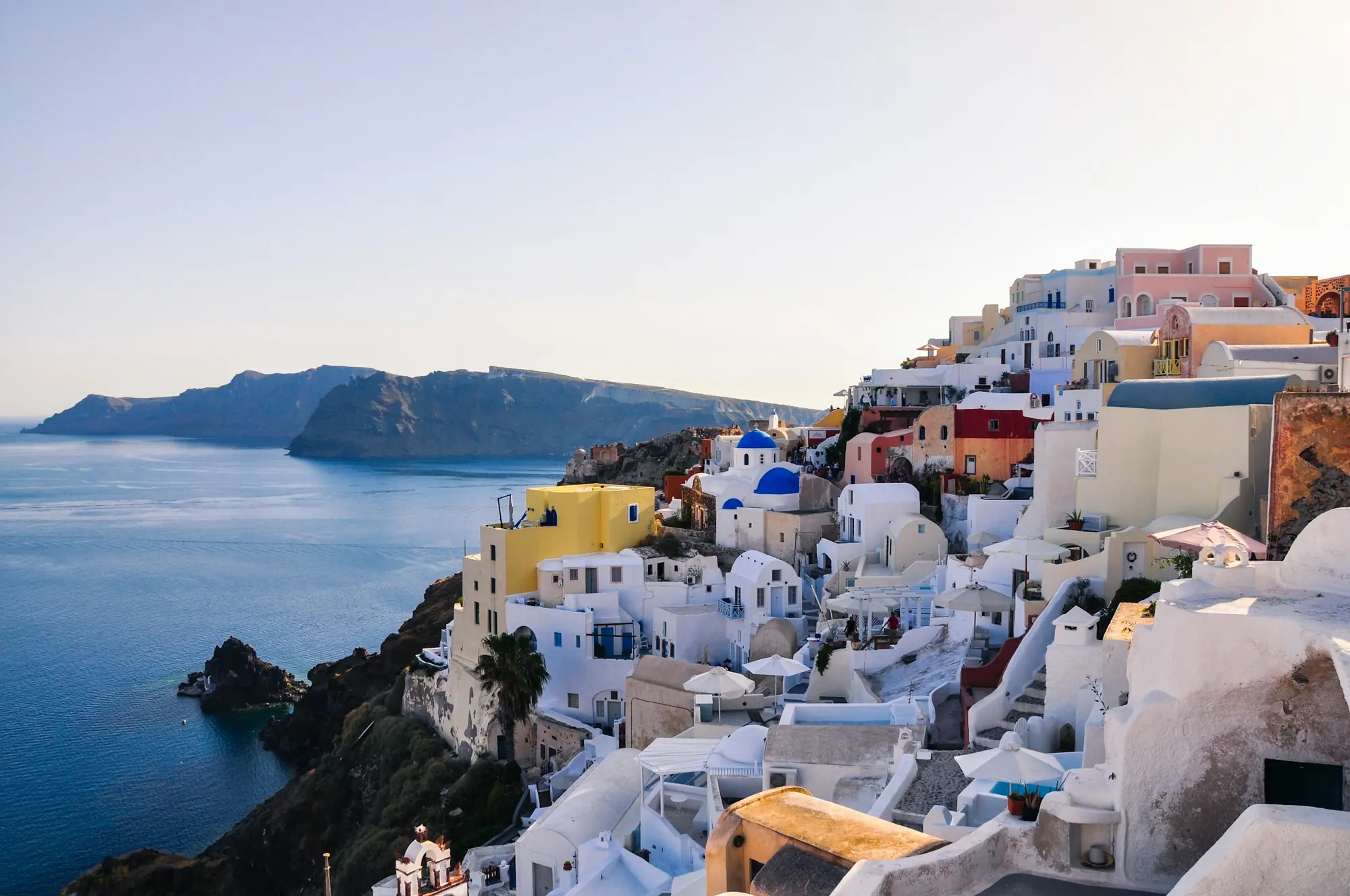 Whitewashed homes above the caldera on Santorini, Greece – Greece residency by investment