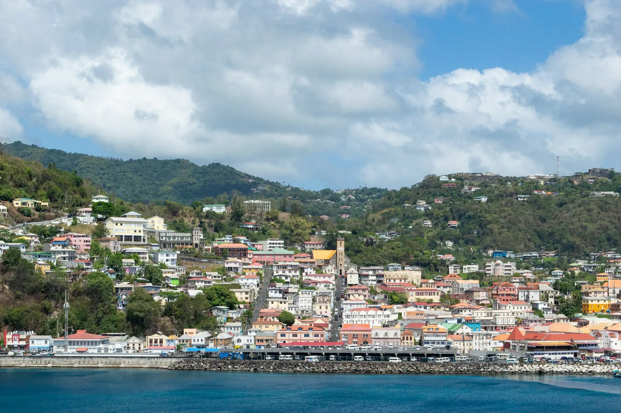 St George's, Grenada, seen from the water with the green hills behind – Grenada Citizenship by Investment